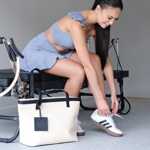 The Bella Tote leather tote bag placed beside a woman at the gym, showing everyday use for an active lifestyle.